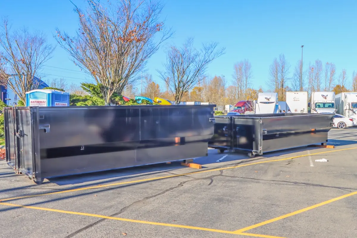 Professional dumpster rental service with roll-off container on residential driveway in Hartland